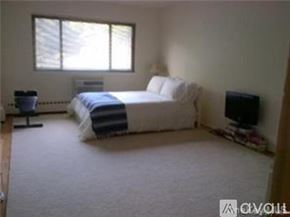Piermont apartment for rent - A pool surrounded by a black fence and green bushes.