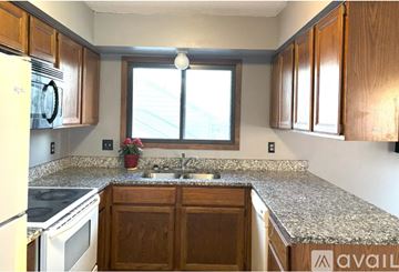 Eden Prairie house for rent - A kitchen with wooden cabinets and granite countertops.