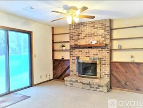 Eden Prairie house for rent - A living room with a fireplace and a ceiling fan.