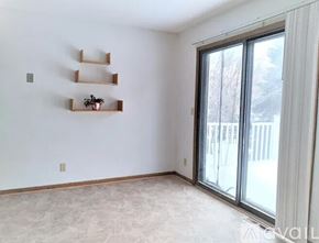 Eden Prairie house for rent - A room with a sliding glass door, a white wall, and a shelf with a plant on it.