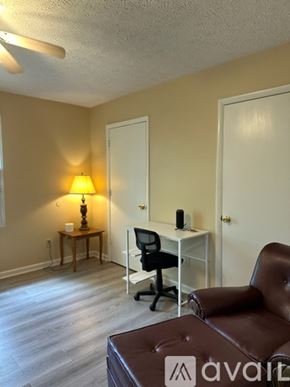 Nashville apartment for rent - A bedroom with a bed, chair, and lamp.