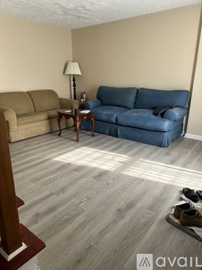 Nashville apartment for rent - A living room with a blue couch, a brown couch, and a lamp.
