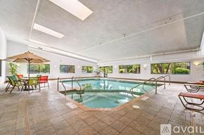 Appleton apartment for rent - A large indoor swimming pool with a glass enclosure and a sun lounger.
