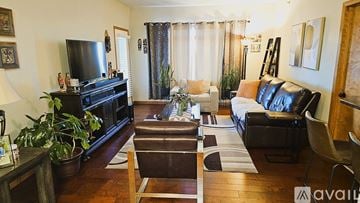 Appleton apartment for rent - A living room with a black leather couch and a wooden coffee table.