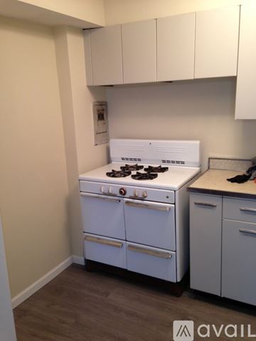 Cleveland apartment for rent - A white stove in a kitchen with white cabinets.