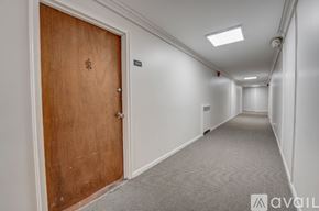 Ewing Township apartment for rent - A long hallway with a wooden door at the end.
