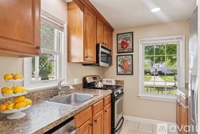 Bay Village house for rent - A kitchen with wooden cabinets and a window showing a view of a street.