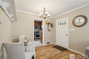 Bay Village house for rent - A dining room with a table set for two and a chandelier hanging from the ceiling.
