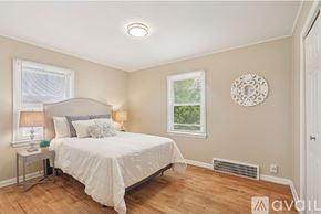 Bay Village house for rent - A bedroom with a bed, two lamps, and a window.