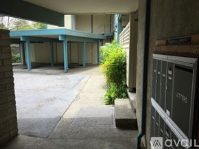 San Anselmo apartment for rent - A concrete walkway leads to a building with a blue roof.