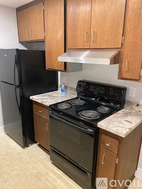 San Anselmo apartment for rent - A kitchen with black appliances and wooden cabinets.