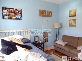 Boston apartment for rent - A bedroom with a bed, a couch, and pictures on the wall.