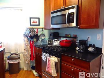 Boston apartment for rent - A kitchen with a black stove top and a black microwave above it.
