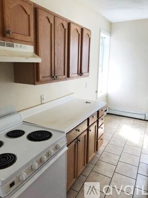 Boston apartment for rent - A kitchen with white appliances and wooden cabinets.