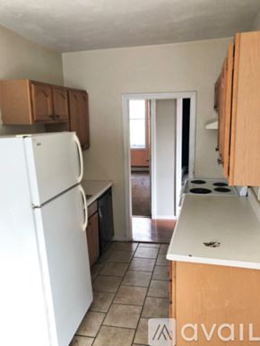Boston apartment for rent - A kitchen with a white refrigerator and wooden cabinets.