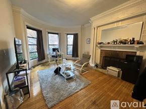 Boston apartment for rent - A living room with a fireplace and a grey rug.