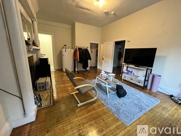 Boston apartment for rent - A living room with a grey rug and a white chair.