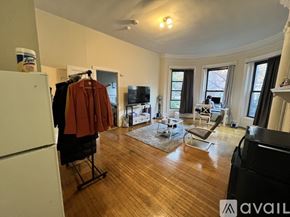 Boston apartment for rent - A living room with a brown coat hanging on a chair.