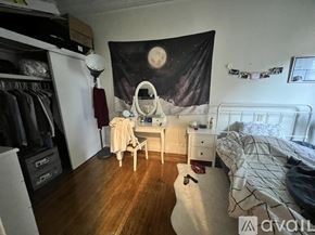 Boston apartment for rent - A bedroom with a bed, a vanity table with a mirror, and a wardrobe.