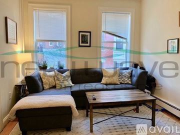 Boston apartment for rent - A living room with a black couch and a wooden coffee table.