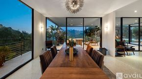 Los Angeles house for rent - A modern dining room with a long wooden table and chairs.