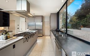 Los Angeles house for rent - A modern kitchen with a stainless steel refrigerator and a view of the outdoors through the window.