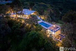 Los Angeles house for rent - A modern house with a pool surrounded by trees at night.