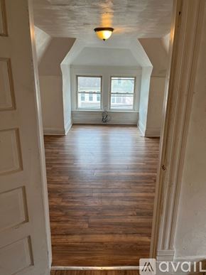 Pittsburgh house for rent - A hallway with wooden floors and white walls leading to a window.