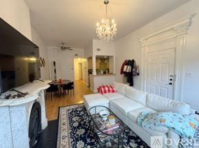 Boston apartment for rent - A spacious room with wooden floors and a white fireplace.