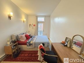 Boston apartment for rent - A bedroom with a bed, desk, chair, and window.
