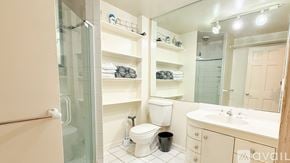 Hartford condo for rent - A bathroom with a glass shower door, a toilet, a sink, and a mirror.