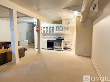 Hartford condo for rent - A living room with a couch and a kitchen area in the background.