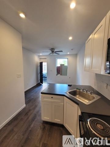 Philadelphia apartment for rent - A kitchen with white cabinets and a black countertop.
