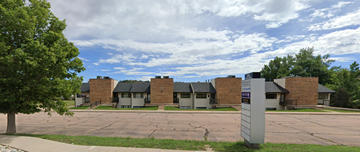 Colorado Springs apartment for rent - A large building with a parking lot in front.