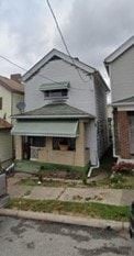 Glassport house for rent - A house with a green awning sits in front of two other houses.