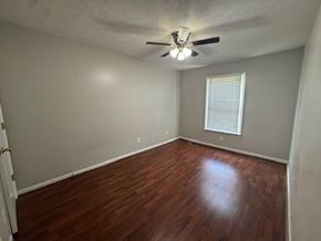 Lawrenceville house for rent - A room with a ceiling fan and wooden flooring.