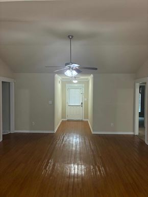 Mobile house for rent - A room with a ceiling fan and wooden floors.