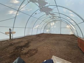 Langley apartment for rent - A greenhouse with soil inside and a wooden post.