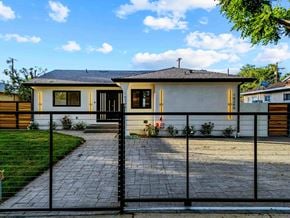 Granada Hills house for rent - A house with a black fence and a brick pathway leading to the front door.