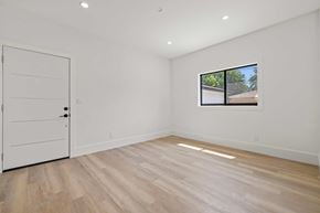 Granada Hills house for rent - A room with a white door and a window with a view of a building outside.