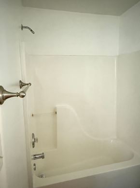 Hampton house for rent - A white bathroom with a tub and shower.