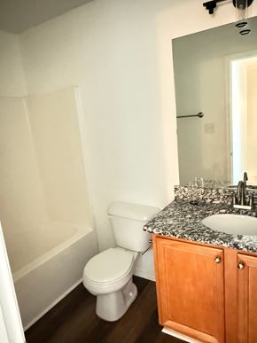 Hampton house for rent - A white toilet sits in a bathroom next to a sink.