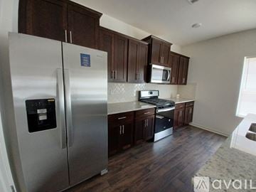 Chelsea house for rent - A kitchen with a stainless steel refrigerator and wooden cabinets.