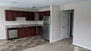 Middletown apartment for rent - A kitchen with brown cabinets and a refrigerator.
