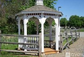 Middletown apartment for rent - A gazebo with a white railing and a brown roof is surrounded by a wooden fence.