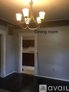 Carterville house for rent - A dining room with a chandelier and a kitchen in the background.