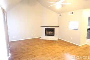 Edmond house for rent - A living room with a fireplace and a ceiling fan.