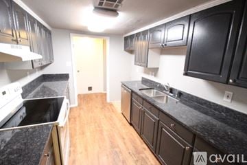 Edmond house for rent - A kitchen with black cabinets and a white stove top oven.