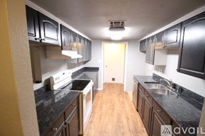 Edmond house for rent - A kitchen with black cabinets and a wooden floor.