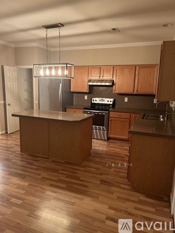 Cornelius house for rent - A kitchen with wooden cabinets and a central island.